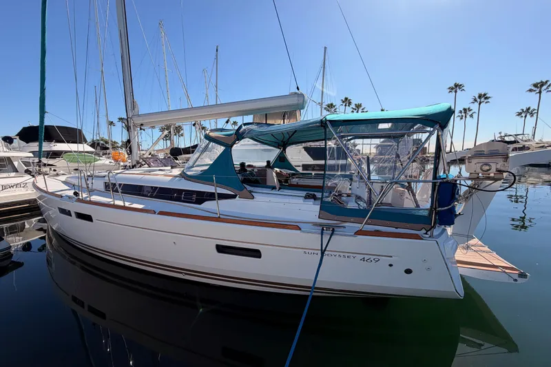 Slide: The Image of 2014 Jeanneau Sun Odyssey 469 sailboat docked in a marina under clear blue skies. - 5