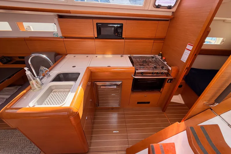 Slide: The Image of 2014 Jeanneau Sun Odyssey 469 yacht kitchen with stove, sink, and microwave. - 50