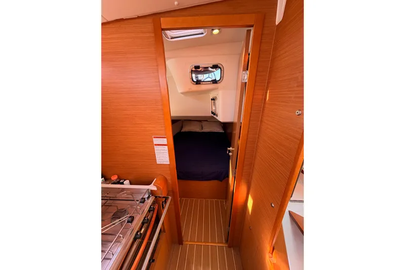 Slide: The Image of Interior cabin of 2014 Jeanneau Sun Odyssey 469 sailboat, featuring a cozy bed and wooden finish. - 53