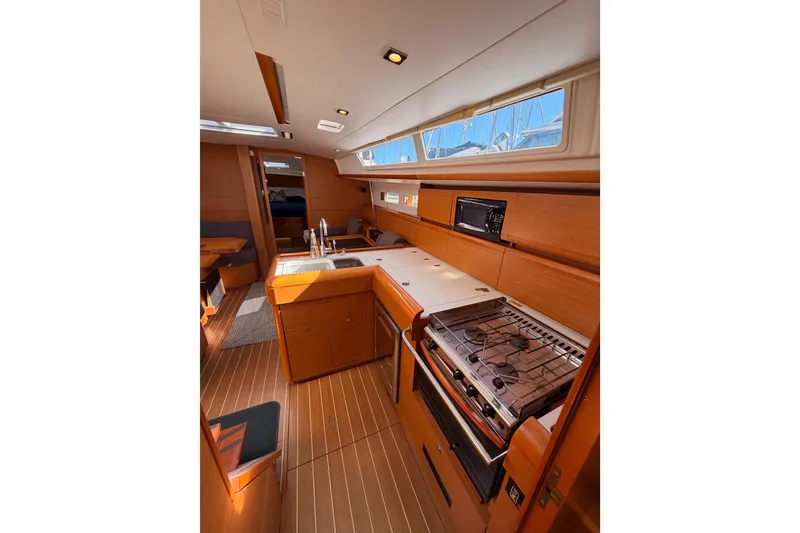Slide: The Image of Interior of 2014 Jeanneau Sun Odyssey 469 yacht, featuring a modern kitchen and dining area. - 56