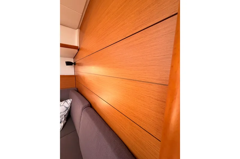 Slide: The Image of Interior of 2014 Jeanneau Sun Odyssey 469, featuring wooden paneling and a gray sofa. - 80