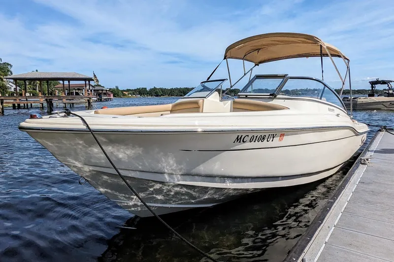 Slide: The Image of 2022 Scout 210 Dorado boat docked on a sunny day, featuring a beige canopy. - 2