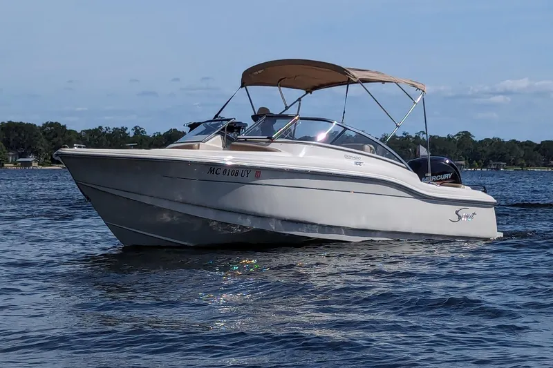 Slide: The Image of 2022 Scout 210 Dorado boat cruising on a lake under a clear sky. - 6