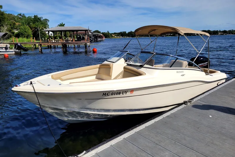 Slide: The Image of 2022 Scout 210 Dorado boat docked on a sunny day by the water. - 8