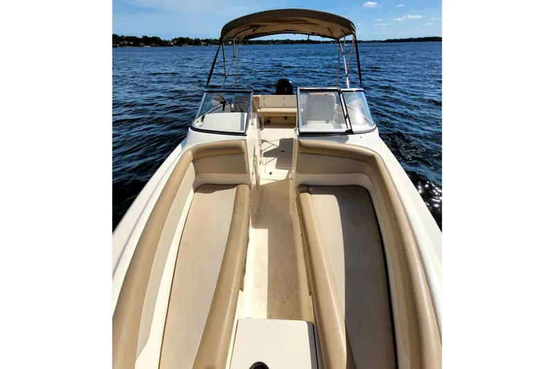 Slide: The Image of 2022 Scout 210 Dorado boat with beige seating, cruising on a sunny day. - 9