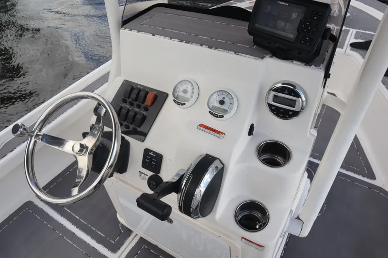 Slide: The Image of 2019 Mako 21 LTS boat console with steering wheel and instruments. - 13