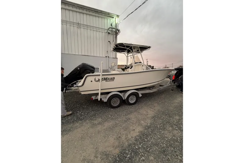 Slide: The Image of 2023 Mako 214 Center Console boat on trailer near industrial building. - 12