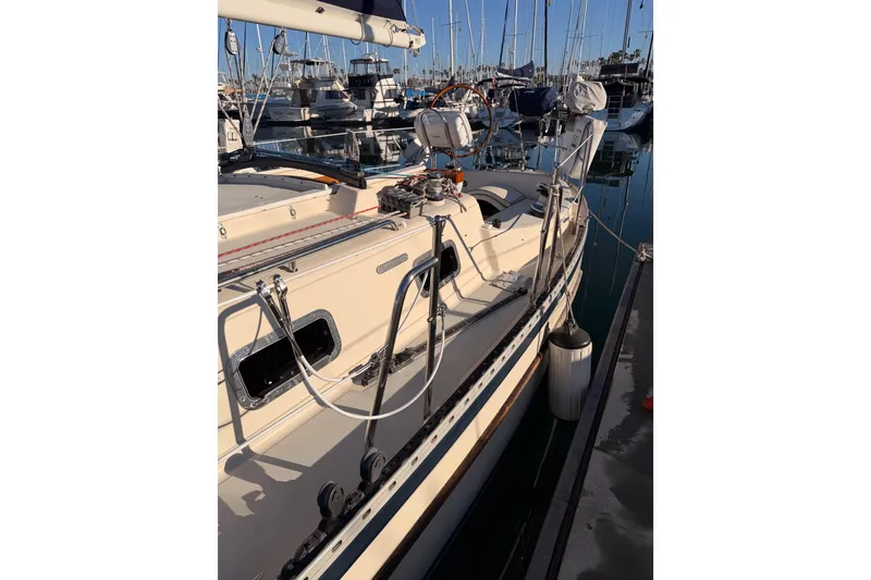 Slide: The Image of 1995 Pacific Seacraft 34 sailboat docked in a marina, showcasing deck and rigging. - 12