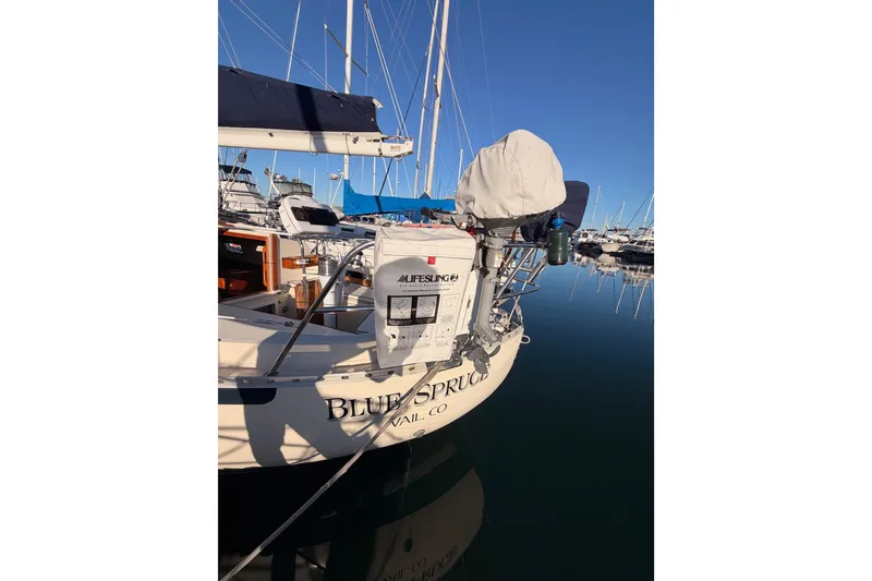 Slide: The Image of 1995 Pacific Seacraft 34 sailboat docked in marina, reflecting on calm water. - 14