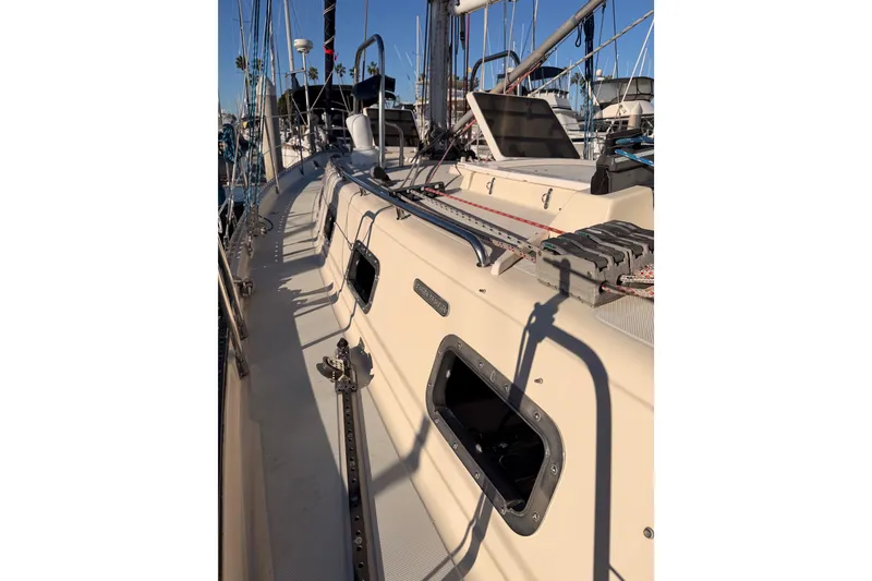 Slide: The Image of 1995 Pacific Seacraft 34 sailboat deck with rigging and portholes in marina. - 16