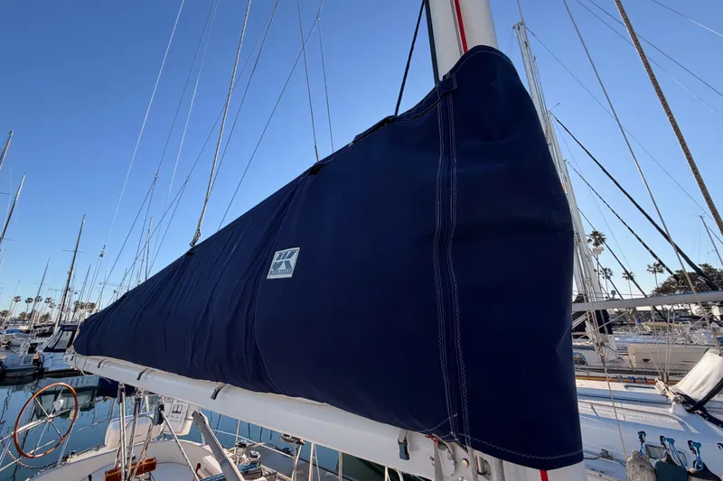 Slide: The Image of 1995 Pacific Seacraft 34 sailboat with blue sail cover in marina setting. - 27