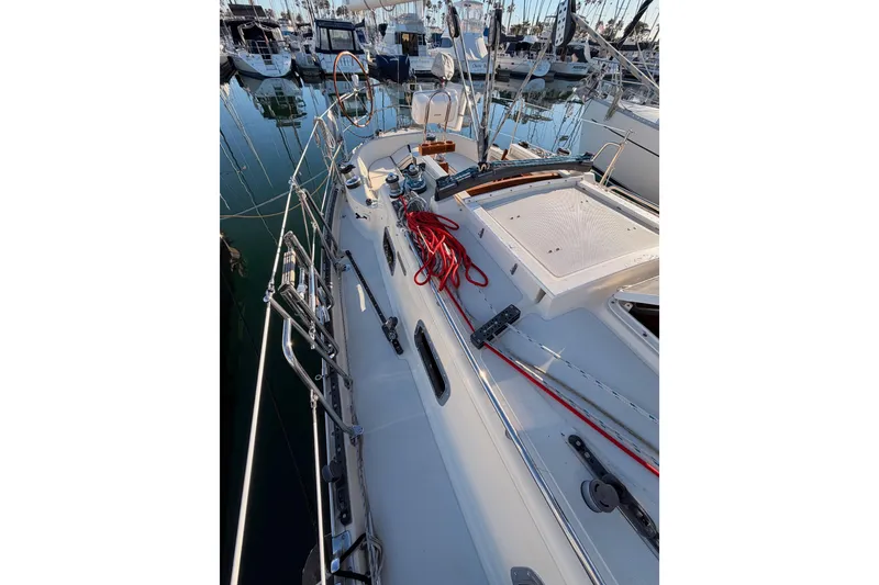 Slide: The Image of 1995 Pacific Seacraft 34 sailboat deck with red ropes, docked in marina. - 28