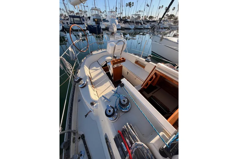 Slide: The Image of 1995 Pacific Seacraft 34 sailboat cockpit with steering wheel, winches, and marina view. - 29