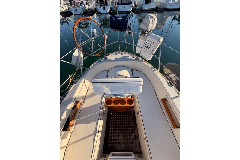 Slide: The Image of 1995 Pacific Seacraft 34 sailboat cockpit with wooden wheel and marina view. - 30