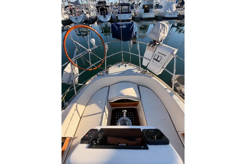 Slide: The Image of Cockpit view of 1995 Pacific Seacraft 34 sailboat in marina, featuring steering wheel and navigation equipment. - 31