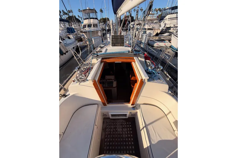 Slide: The Image of 1995 Pacific Seacraft 34 sailboat cockpit with open cabin door, docked at marina. - 35