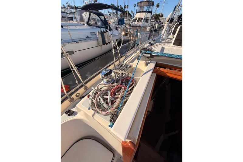 Slide: The Image of 1995 Pacific Seacraft 34 sailboat deck with ropes and winch in marina. - 36