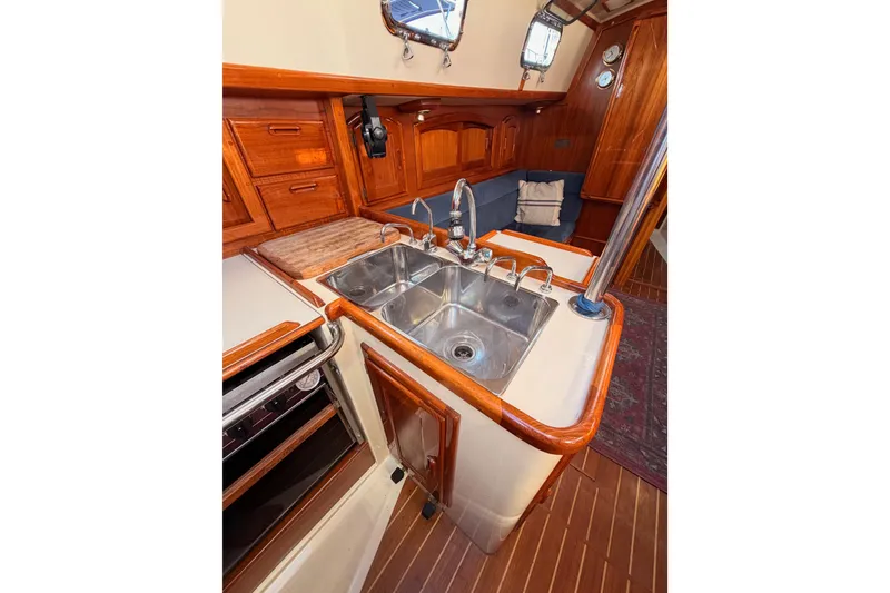 Slide: The Image of Interior of 1995 Pacific Seacraft 34 sailboat with wooden cabinetry and stainless steel sink. - 46