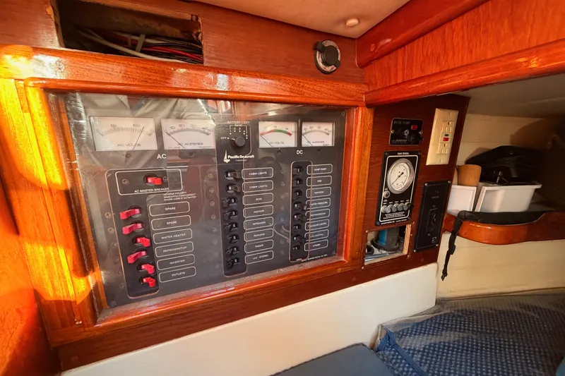 Slide: The Image of Electrical control panel on a 1995 Pacific Seacraft 34 sailboat, featuring AC and DC switches. - 50