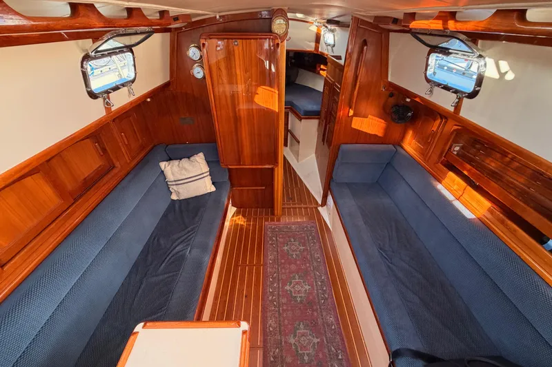 Slide: The Image of Interior of 1995 Pacific Seacraft 34 sailboat with wooden finish and blue seating. - 52