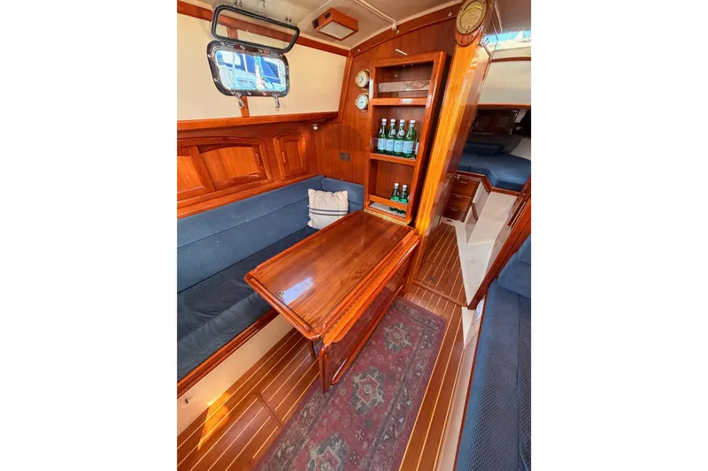 Slide: The Image of Interior of 1995 Pacific Seacraft 34 sailboat with wooden table and seating area. - 53
