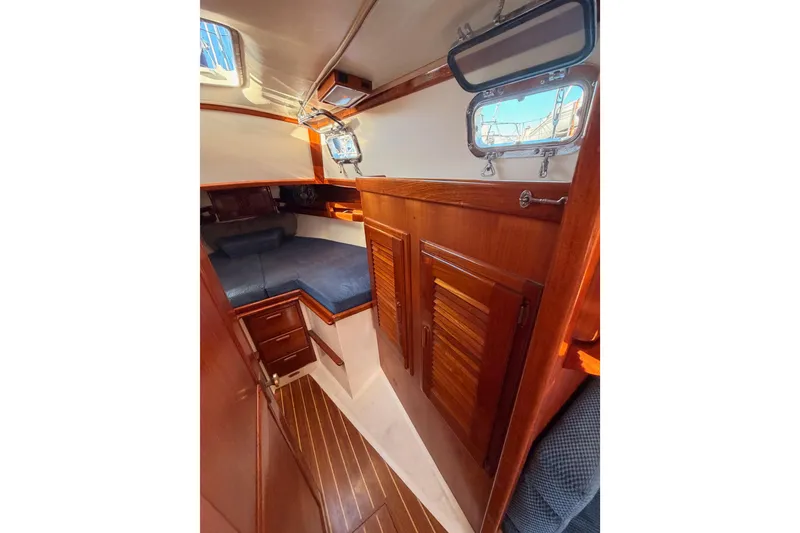 Slide: The Image of Interior of 1995 Pacific Seacraft 34 sailboat with wooden cabinetry and cozy sleeping area. - 63