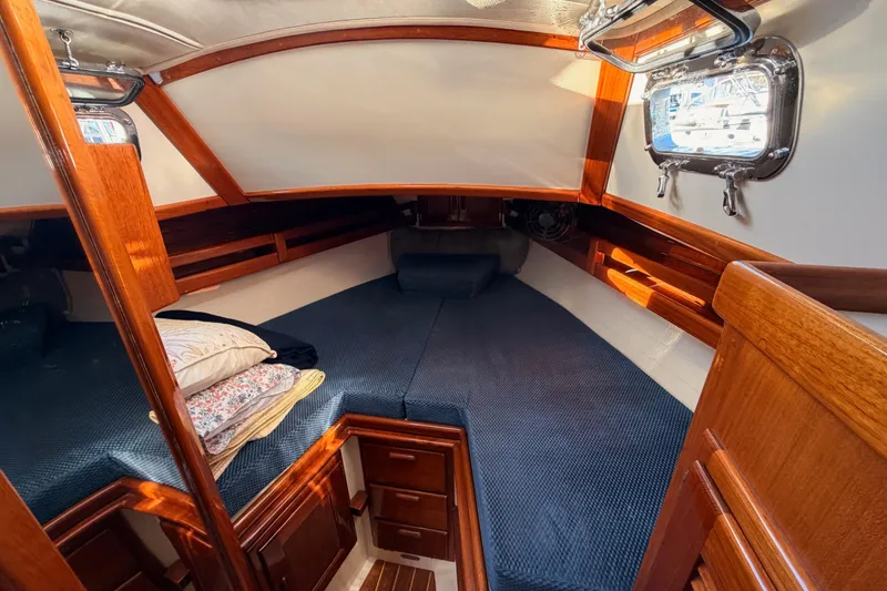 Slide: The Image of Cozy cabin interior of 1995 Pacific Seacraft 34 sailboat with wooden finish and bedding. - 64