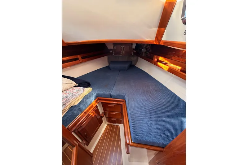 Slide: The Image of Cozy cabin interior of 1995 Pacific Seacraft 34 sailboat with blue bedding and wooden accents. - 65