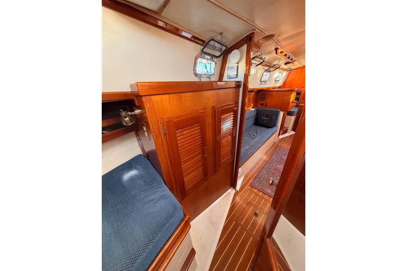 Slide: The Image of Interior of 1995 Pacific Seacraft 34 sailboat with wooden cabinetry and blue seating. - 67