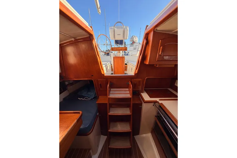 Slide: The Image of Interior view of 1995 Pacific Seacraft 34 sailboat with wooden cabinetry and steps. - 70