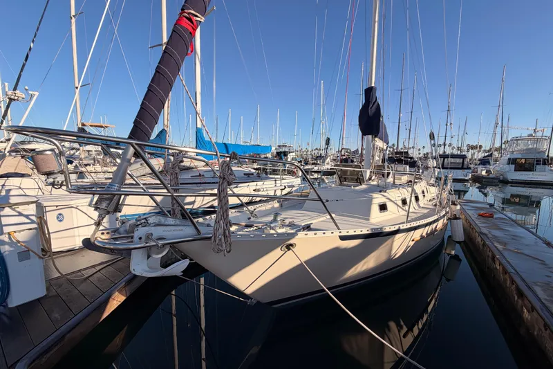 Slide: The Image of 1995 Pacific Seacraft 34 sailboat docked in a marina, surrounded by other boats. - 8
