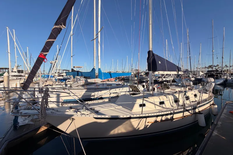 Slide: The Image of 1995 Pacific Seacraft 34 sailboat docked in a marina, surrounded by other vessels. - 9