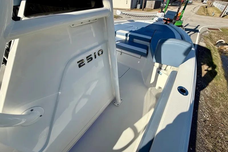 Slide: The Image of 2022 Ranger 2510 Bay boat interior with seating and console, parked on a trailer. - 16