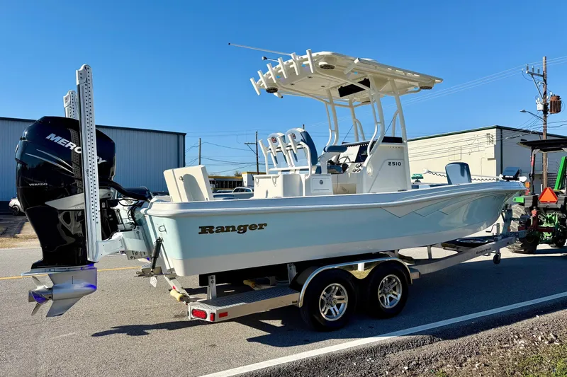 Slide: The Image of 2022 Ranger 2510 Bay boat on trailer with Mercury engine, parked outdoors. - 4
