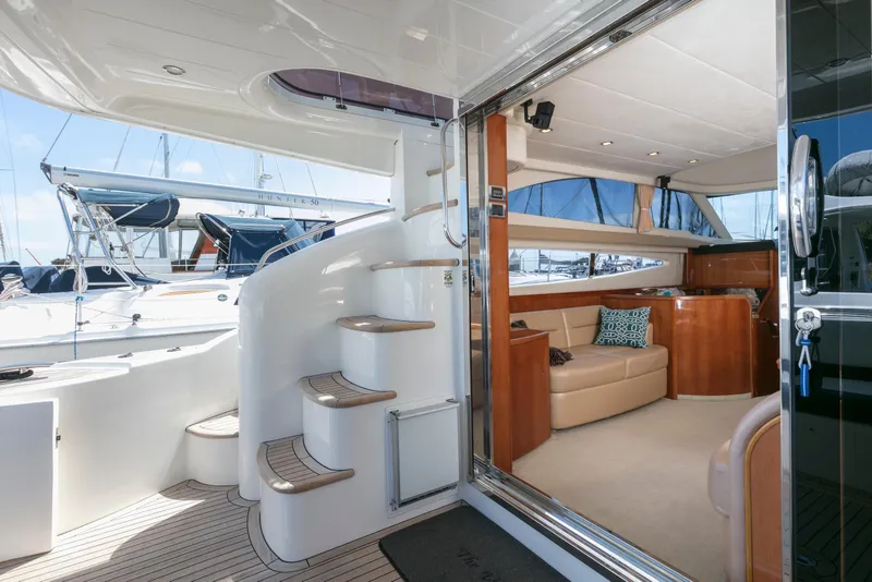 Slide: The Image of 2007 Viking Sport Cruiser interior with elegant seating and spiral staircase, docked at marina. - 11