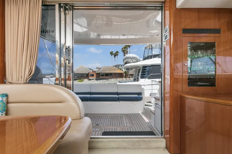 Slide: The Image of Interior view of a 2007 Viking Sport Cruiser yacht, featuring elegant seating and a scenic outdoor view. - 16