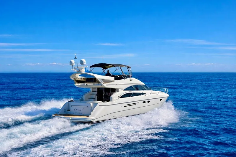 Slide: The Image of 2007 Viking Sport Cruisers 50 yacht cruising on open blue sea under clear sky. - 2