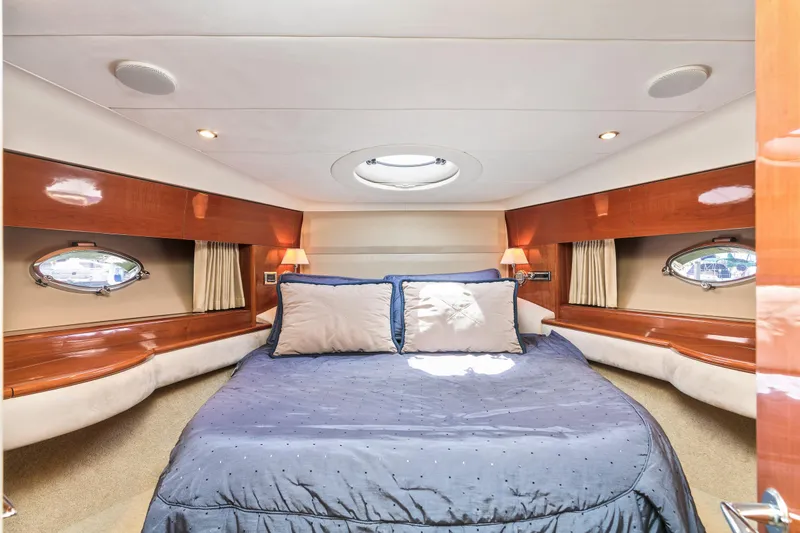 Slide: The Image of Luxurious cabin interior of 2007 Viking Sport Cruiser with cozy bed and elegant wood finish. - 26