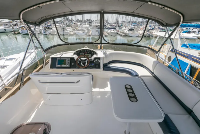 Slide: The Image of 2007 Viking Sport Cruiser helm with marina view, featuring seating and navigation controls. - 33