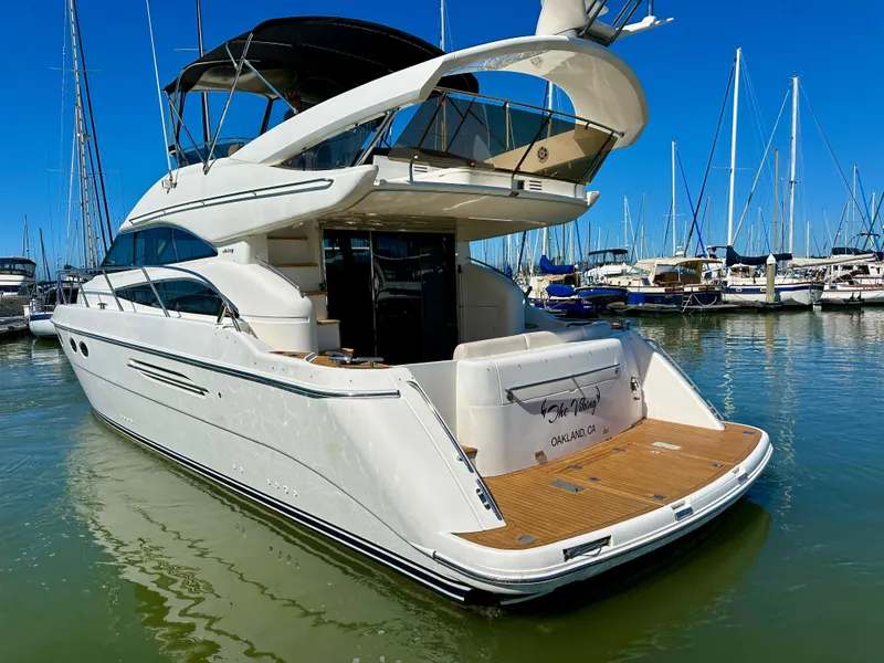 Slide: The Image of Luxury 2007 Viking Sport Cruiser yacht docked in marina under clear blue sky. - 6
