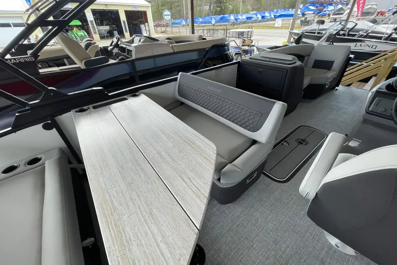 Slide: The Image of 2026 Harris Sunliner 230 pontoon boat interior with seating and table setup. - 10