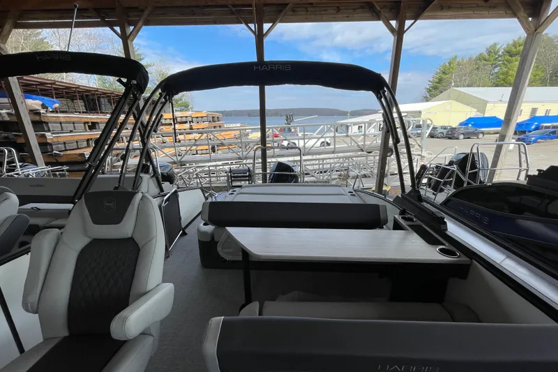 Slide: The Image of 2026 Harris Sunliner 230 pontoon boat interior under a wooden shelter. - 11