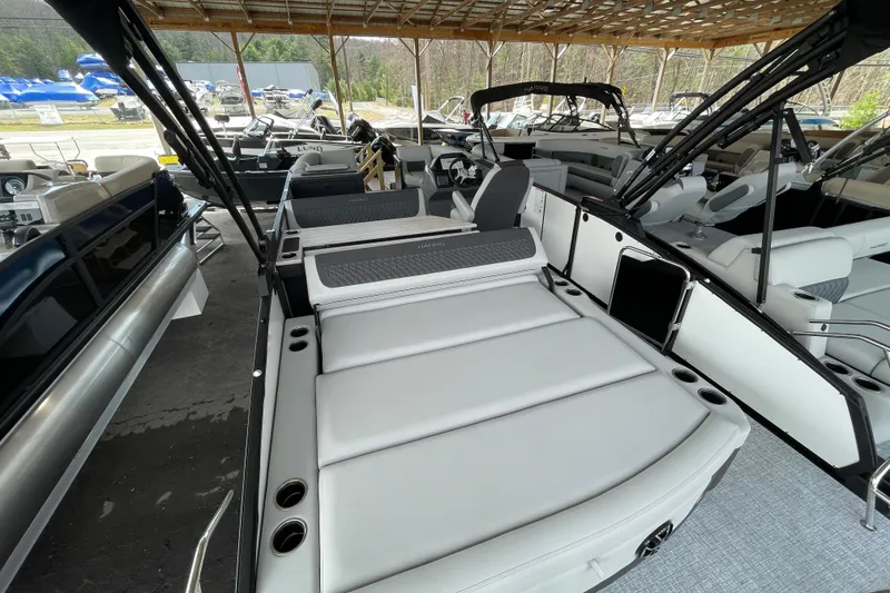 Slide: The Image of 2026 Harris Sunliner 230 pontoon boat with spacious seating and modern design under a covered dock. - 13