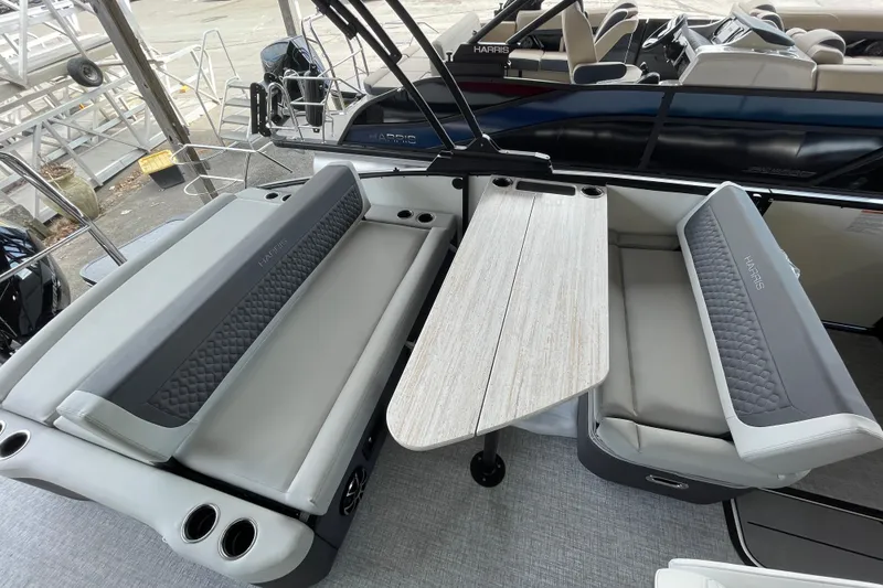 Slide: The Image of 2026 Harris Sunliner 230 boat interior with gray seating and a central table. - 8