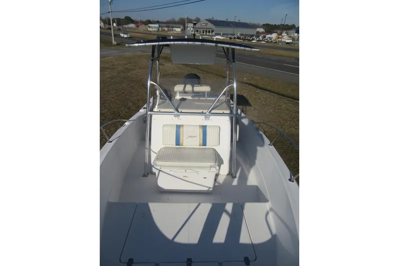 Slide: The Image of 2000 Sport-Craft 24 CC boat with center console and seating, parked on grass. - 11