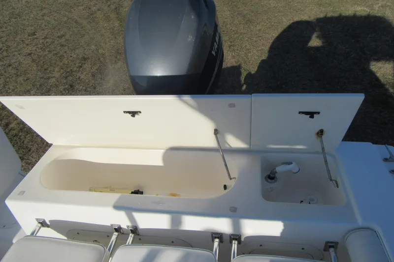 Slide: The Image of Sport-Craft 24 CC 2000 boat with open storage compartments and visible engine. - 19