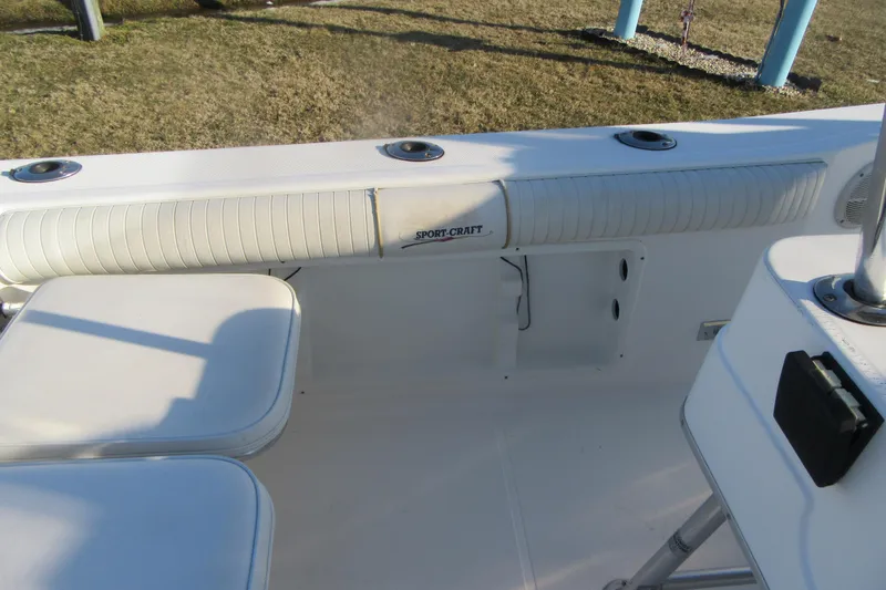 Slide: The Image of 2000 Sport-Craft 24 CC boat interior with white seating and rod holders. - 21