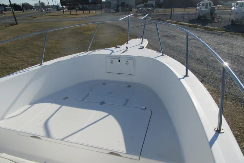 Slide: The Image of 2000 Sport-Craft 24 CC boat deck with stainless steel railings, parked on land. - 8