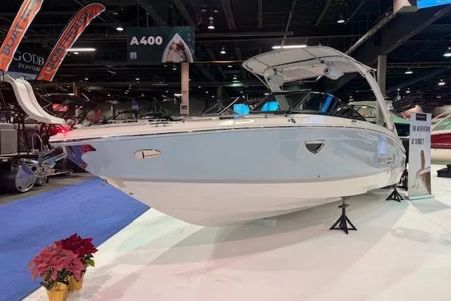 Slide: The Image of 2026 Regal LS6 Surf boat displayed at an indoor exhibition, showcasing sleek design. - 1