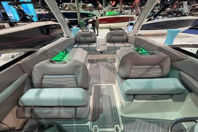 Slide: The Image of 2026 Regal LS6 Surf boat interior with luxurious seating and ambient lighting at a boat show. - 14